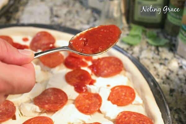 adding sauce pepperoni pizza