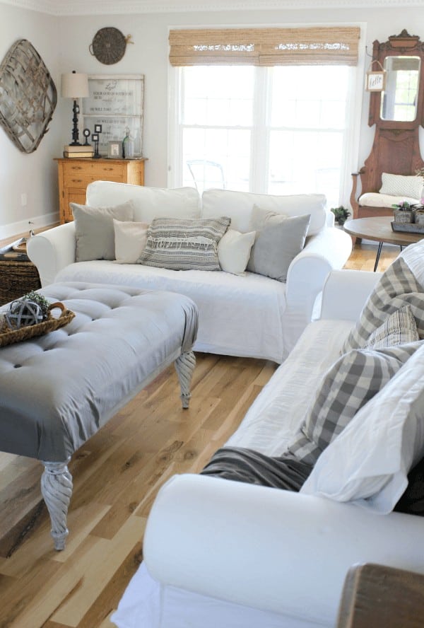 Farmhouse living room filled with woven shades and vintage furniture.