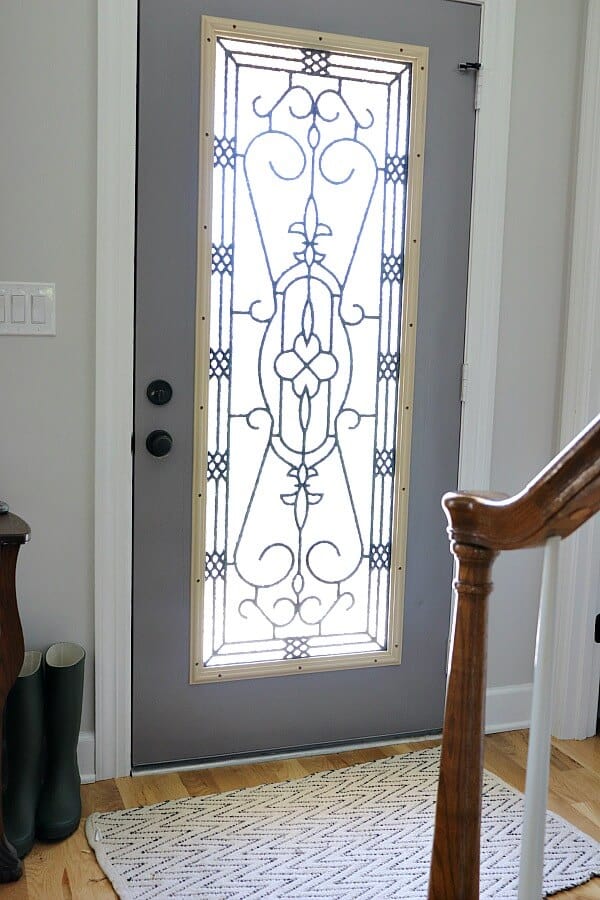 Do you live with an ugly dated door? Here is how we brightened our Entryway with a DIY Glass Door Insert. It's scary to think you can cut a hole in your front door, but look at this amazing transformation!