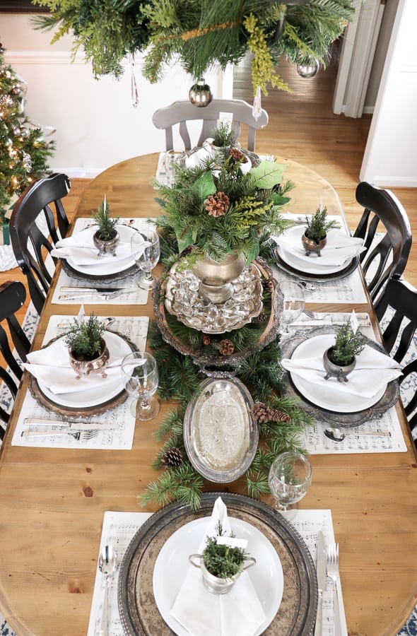christmas tablescape using sheet music as placemats, tarnished silver trays as chargers and vintage silver and crystal 