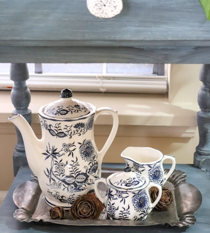 vintage tea set on a metal serving tray with pinecone florets