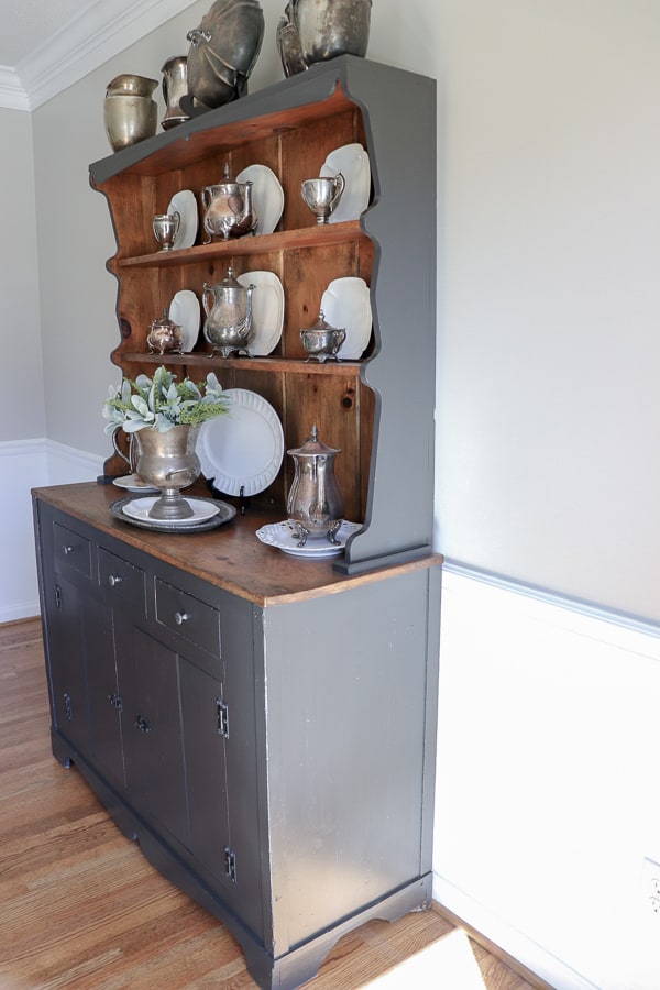 I love when furniture tells a story that takes you back in time. Our updated hutch is a classic vintage piece. This is the third version and I'm loving the classic painted gray hutch complete with all my tarnished silver!