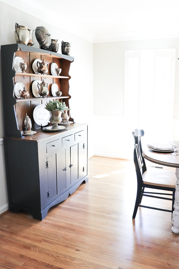 I love when furniture tells a story that takes you back in time. Our updated hutch is a classic vintage piece. This is the third version and I'm loving the classic painted gray hutch complete with all my tarnished silver!