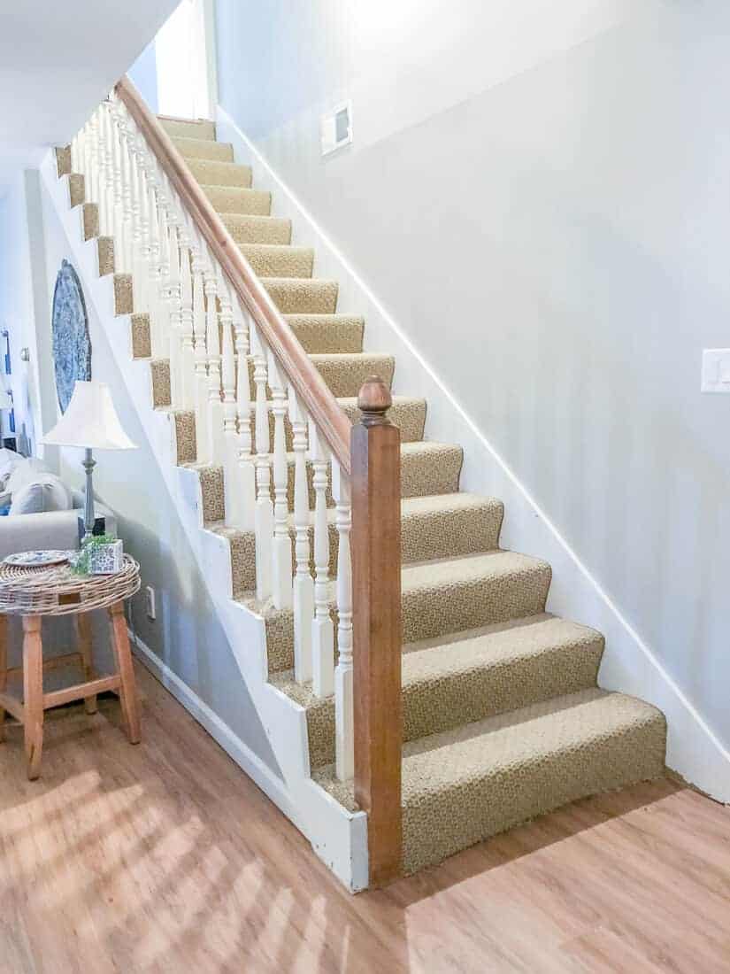 dated basement stairs with wood balusters and ugly carpet