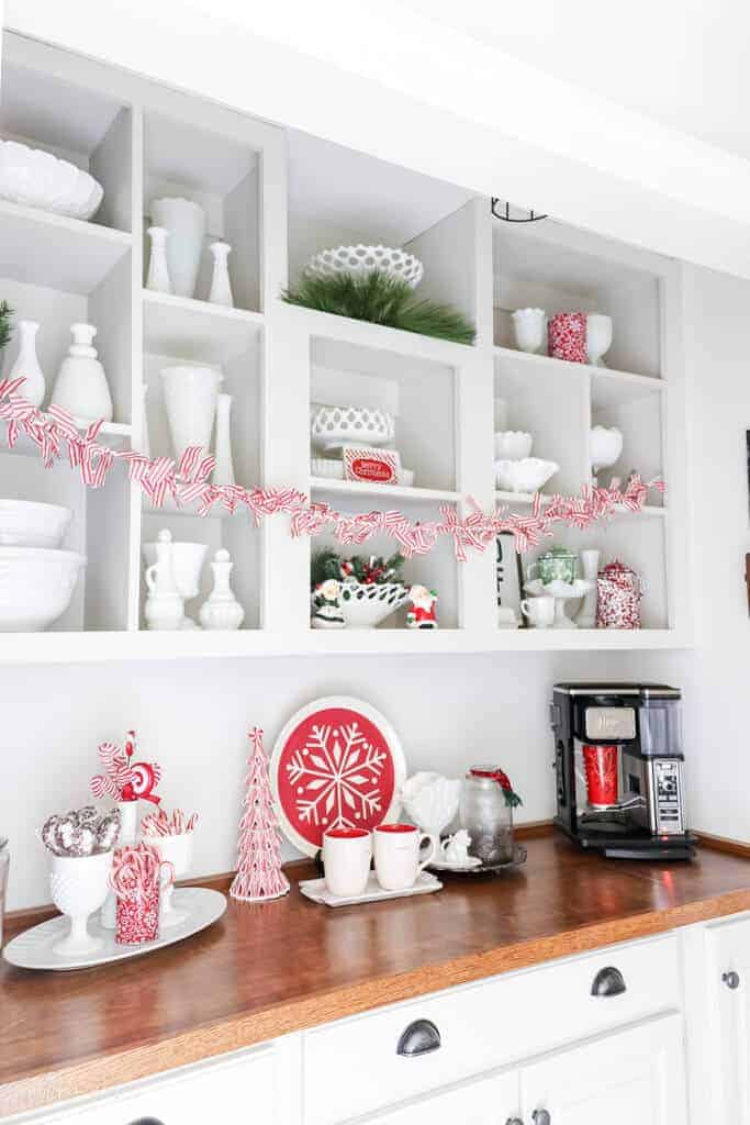 butters pantry with open shelving decorated for Christmas with milk glass and candy cane themed decor