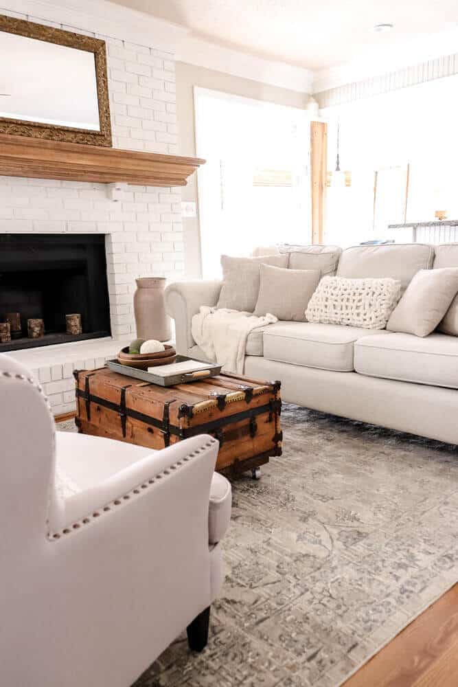 cream and tan couch and chairs with a vintage trunk coffee table