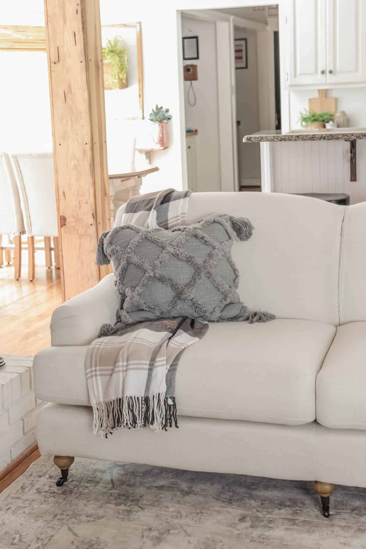 gray pillow with plaid throw