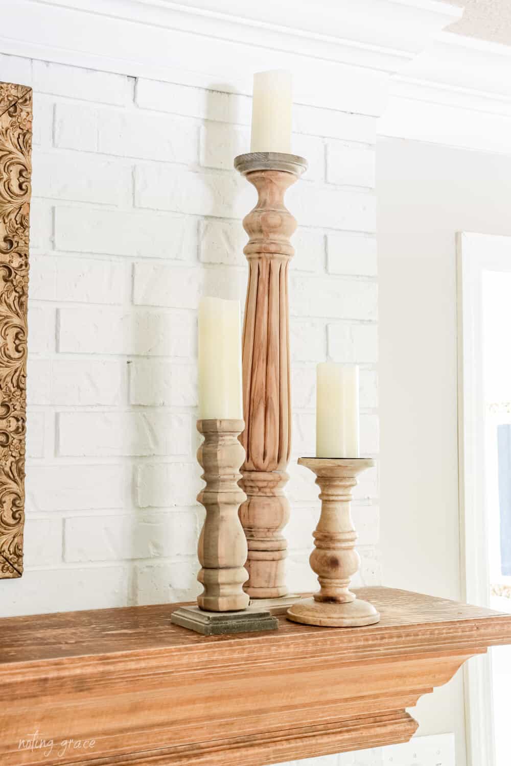 DIY candlesticks made from bedposts displayed on a fireplace mantel