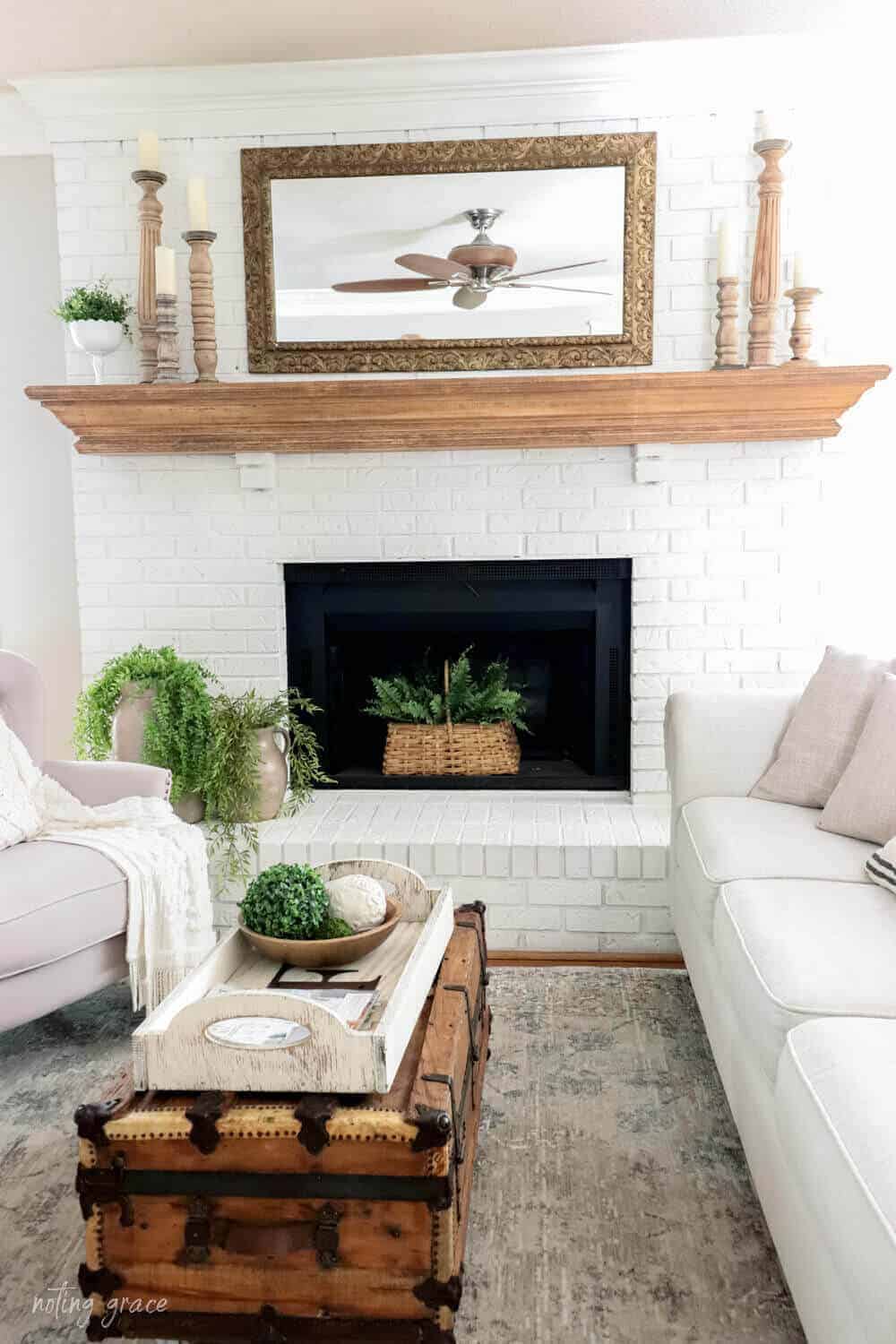 white painted brick fireplace with natural wood mantel and wooden candlesticks
