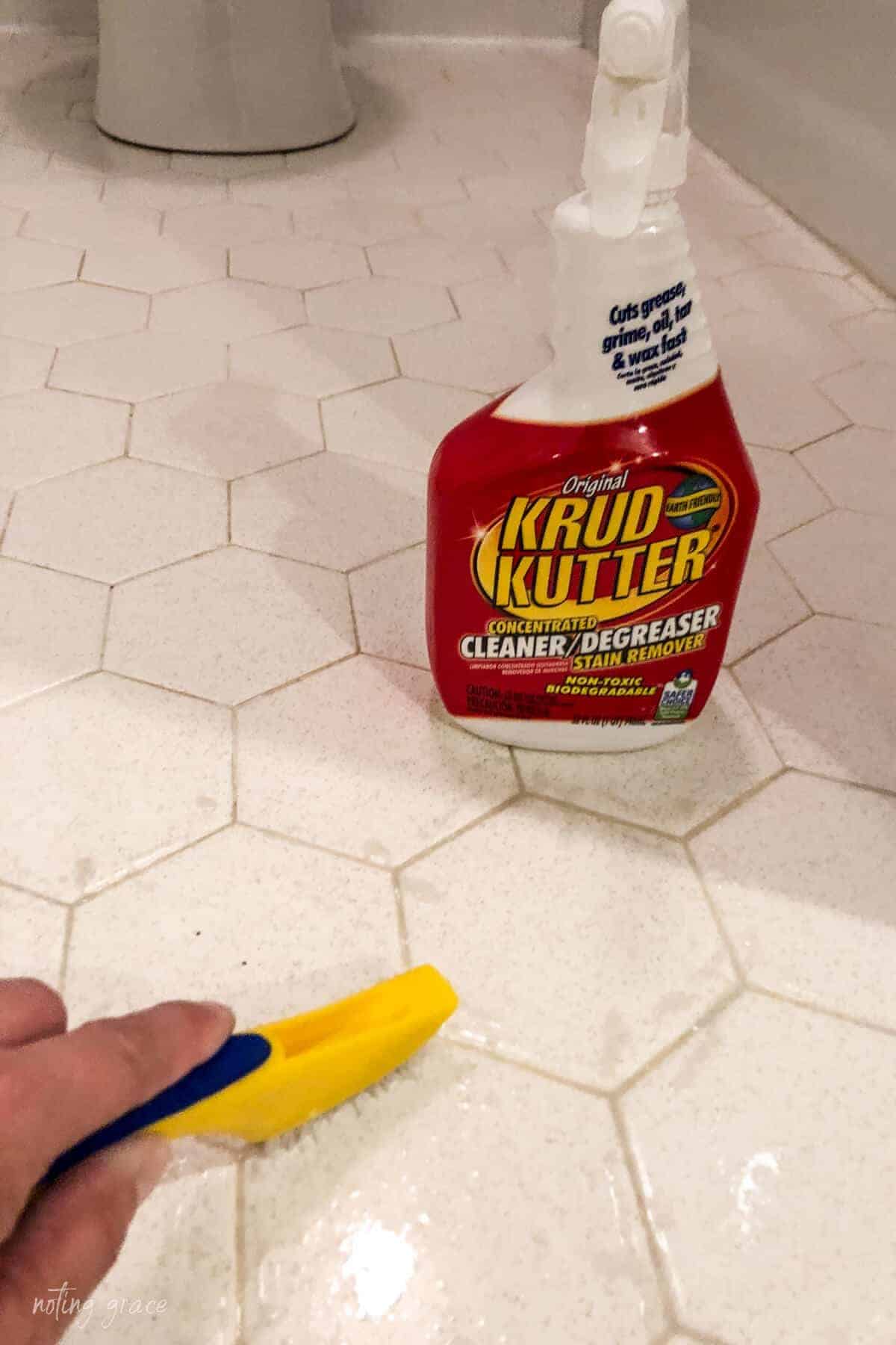 scrubbing hexagon floor tile grout using Krud Kutter cleaner and scrub brush