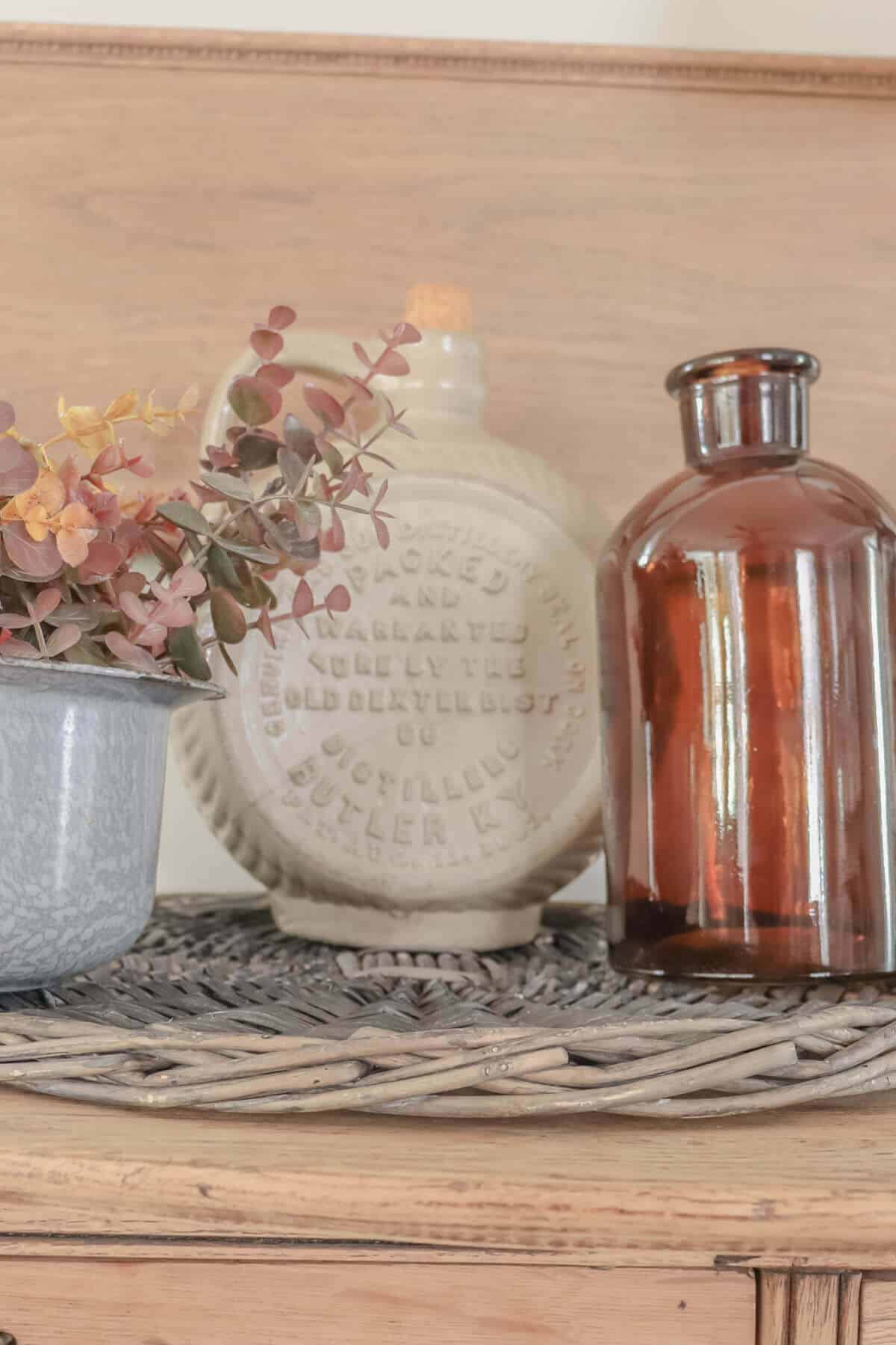 vintage crocks, amber bottles and gray spatterware in a fall arrangement