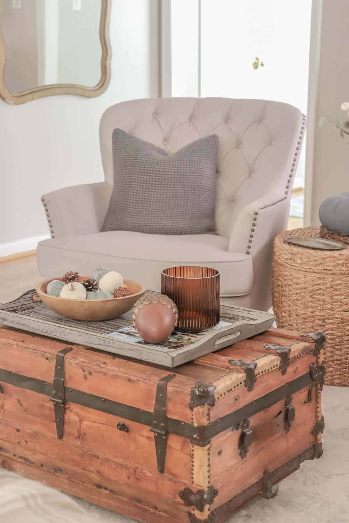 armchair with gray pillows with vintage wooden crate as a coffee table decorated for fall