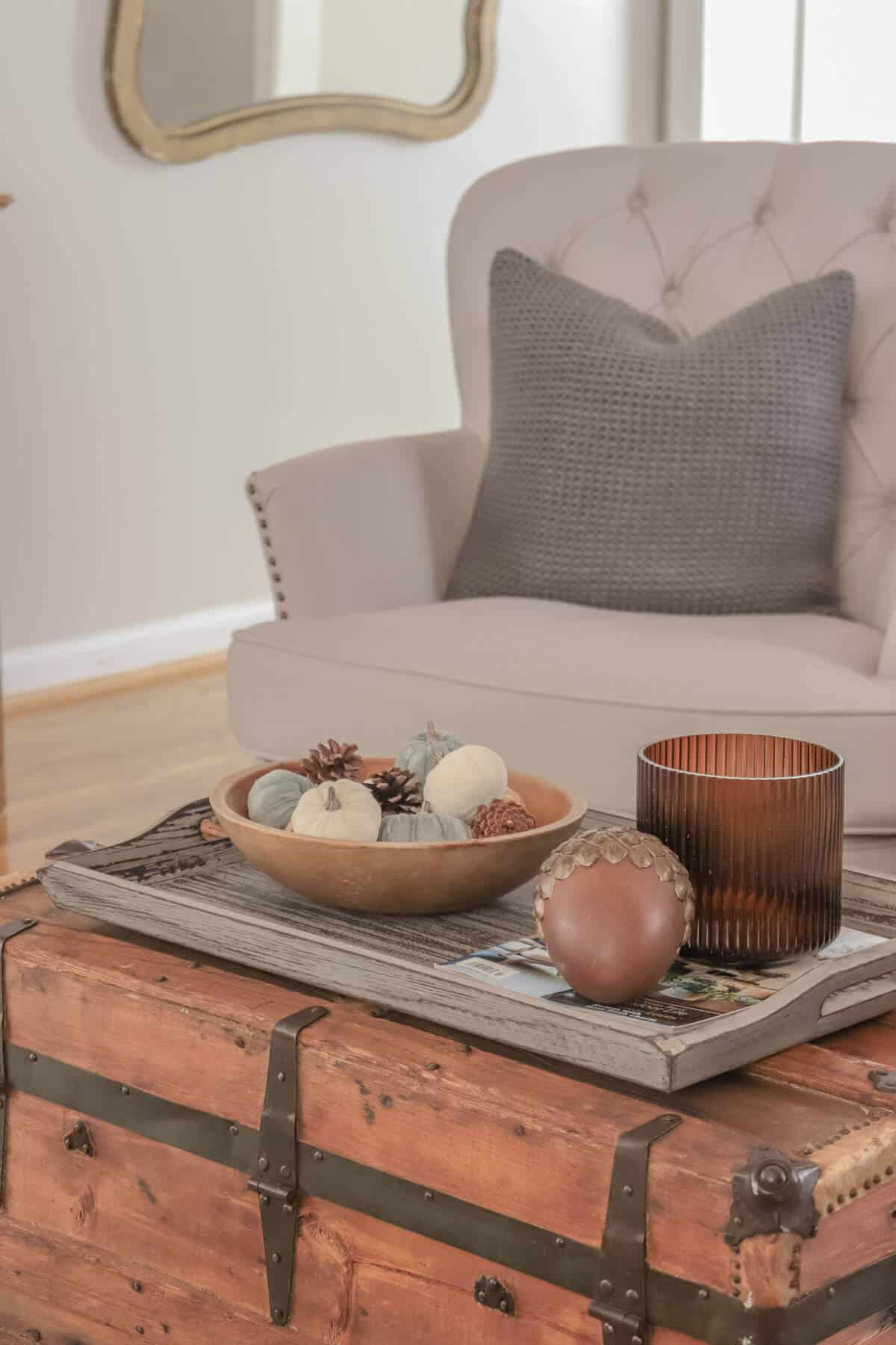 armchair with gray pillows with vintage wooden crate as a coffee table decorated for fall
