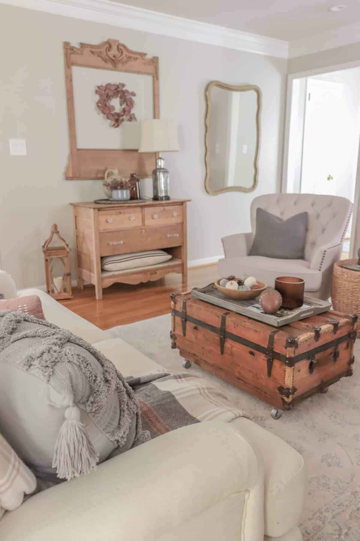 armchair with gray pillows with vintage wooden crate as a coffee table decorated for fall with gray fall decor