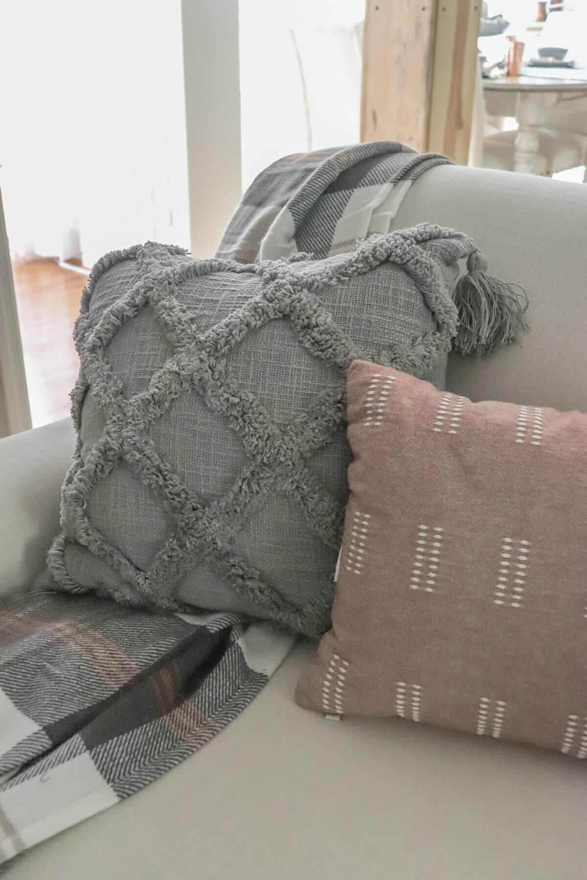 gray pillow with plaid throw
