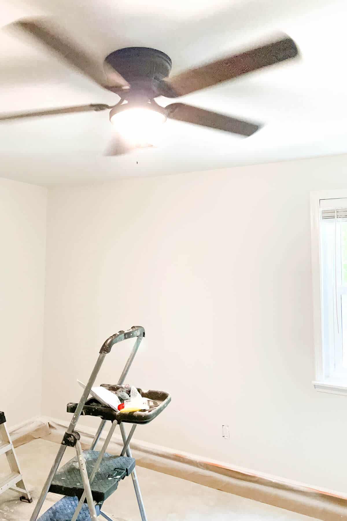 white painted walls and black and brown ceiling fan