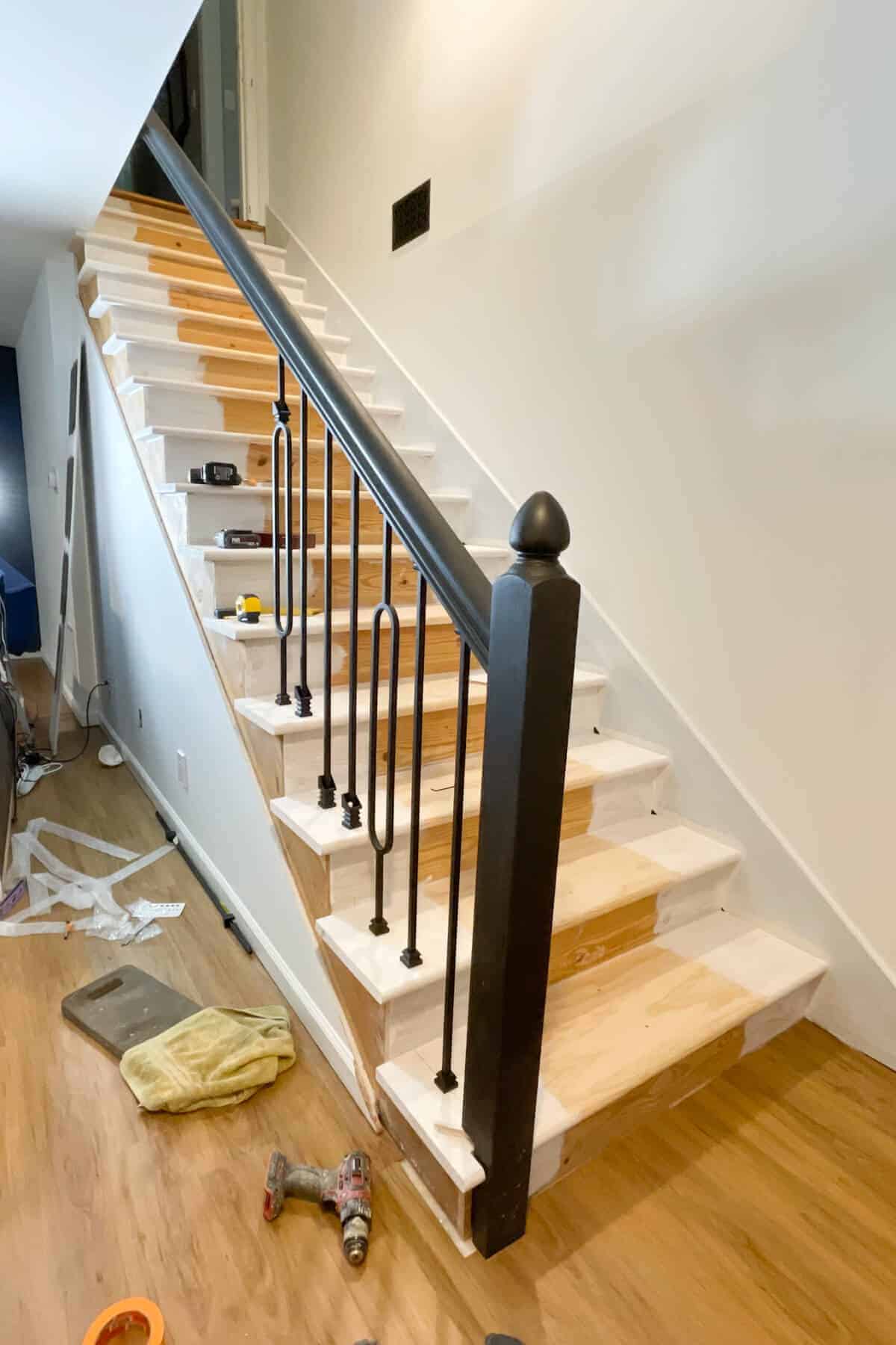 basement staircase with iron balusters being installed.