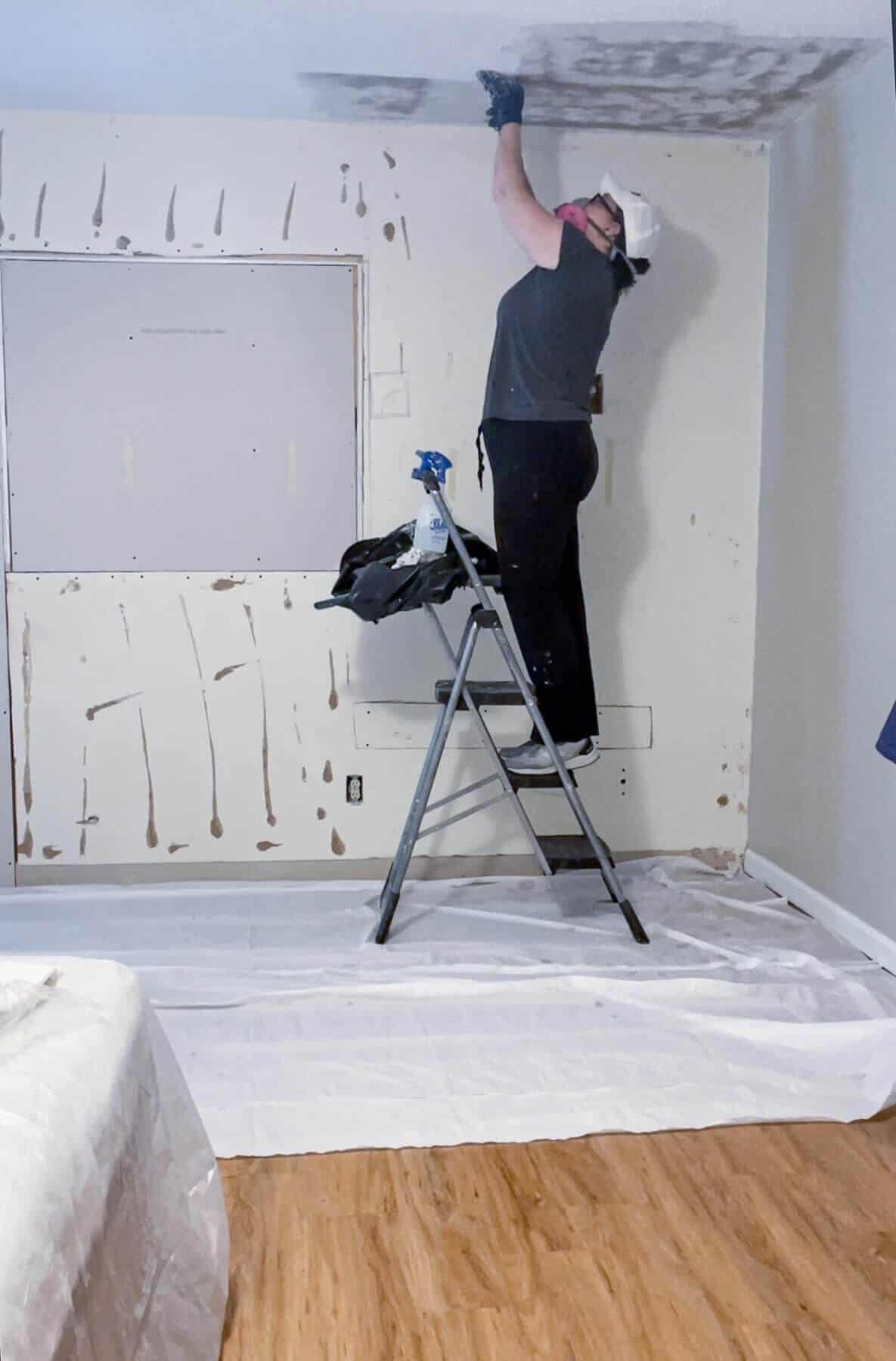 woman scraping a popcorn ceiling