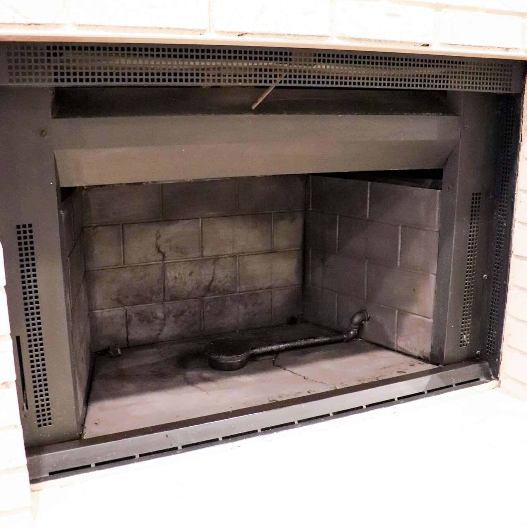 gas log lighter in a fireplace that has been painted black