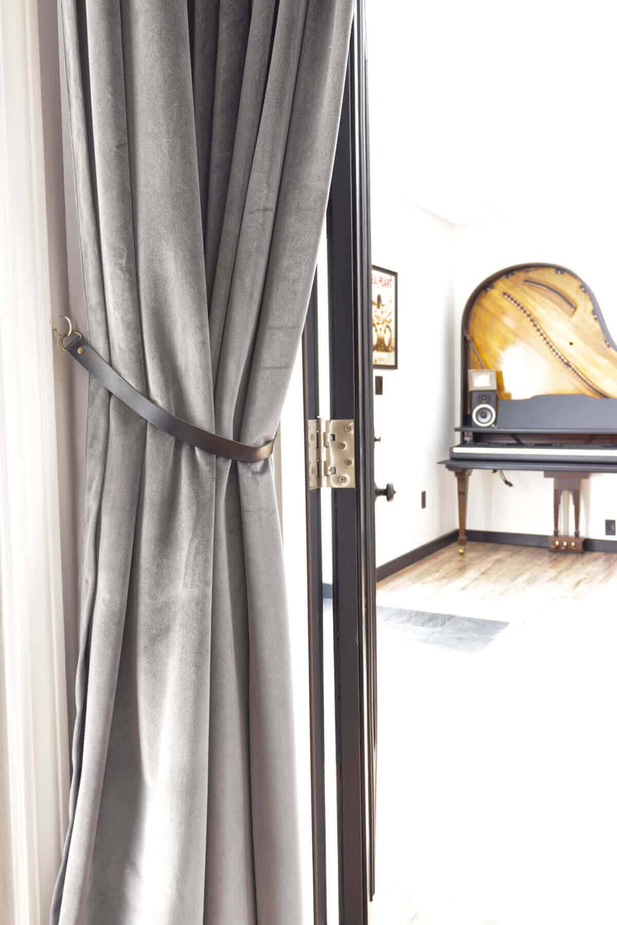 gray velvet curtains with a leather tie back
