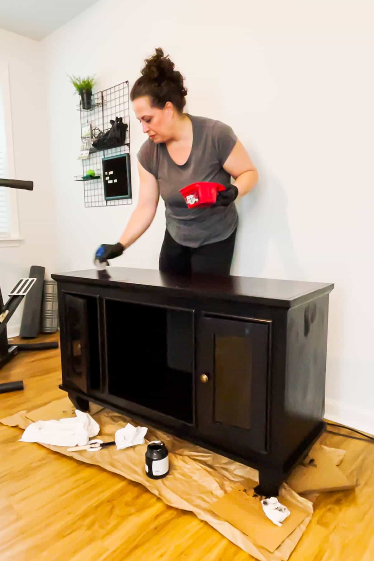 woman painting an old entertainment center