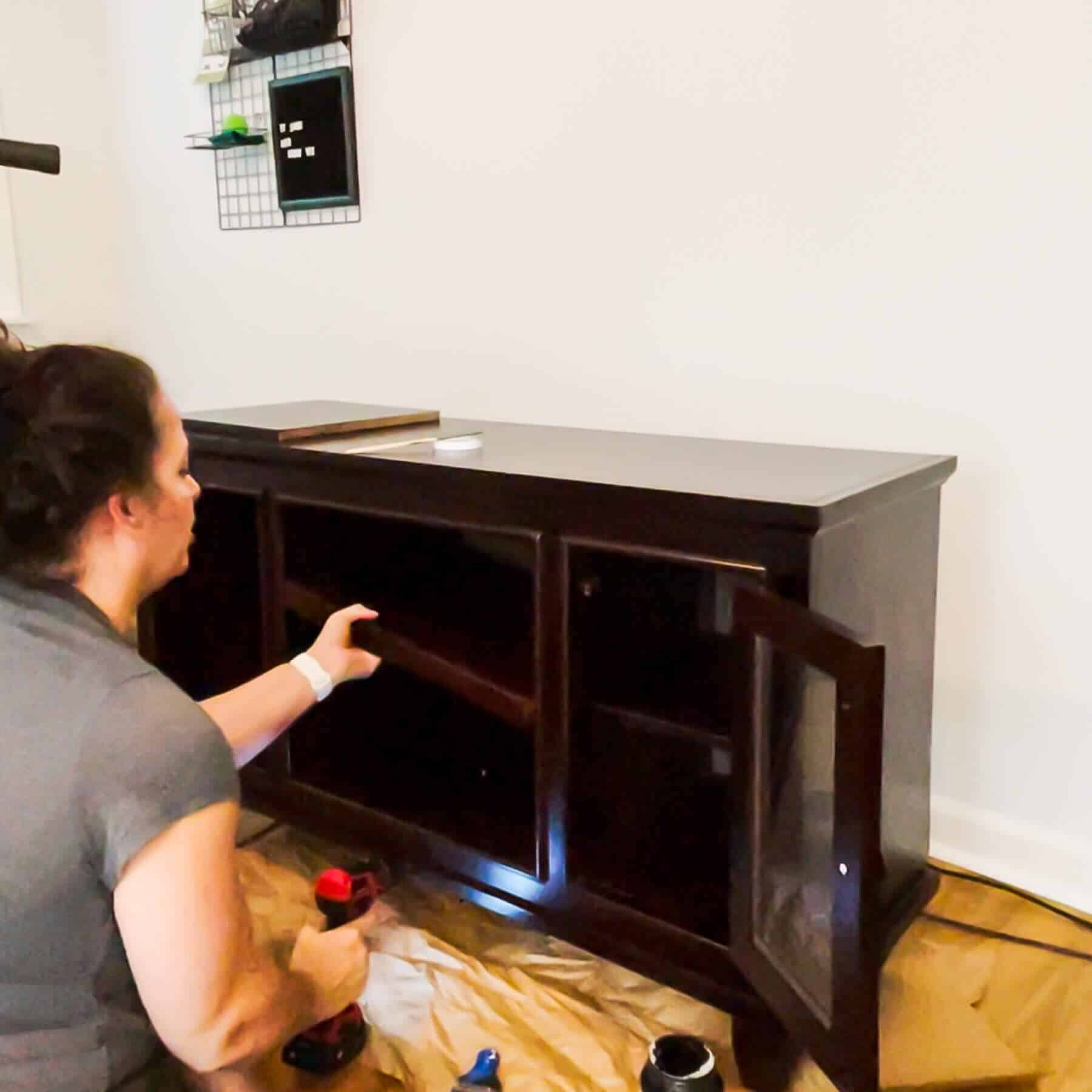 woman removing shelves from an entertainment center