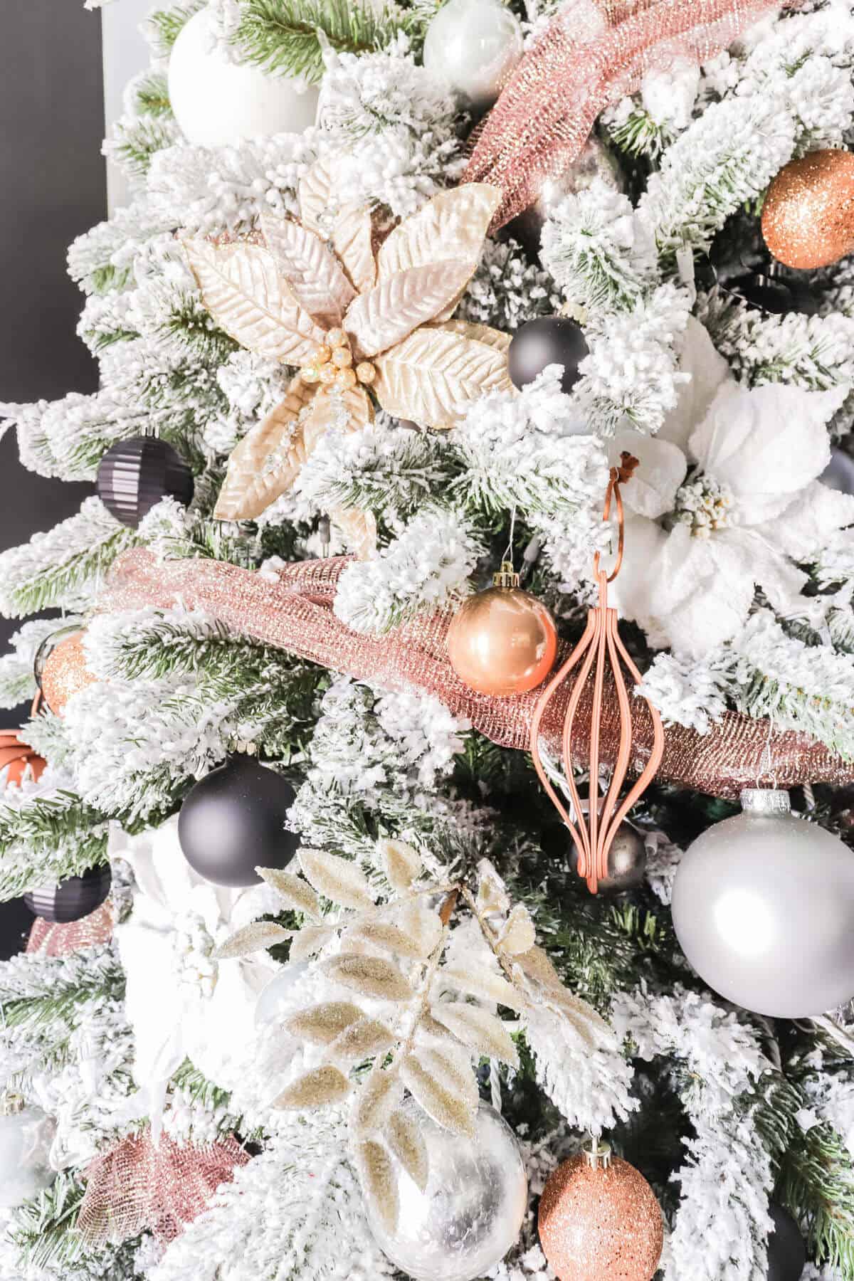 flocked tree with copper, leather, gray and black ornaments