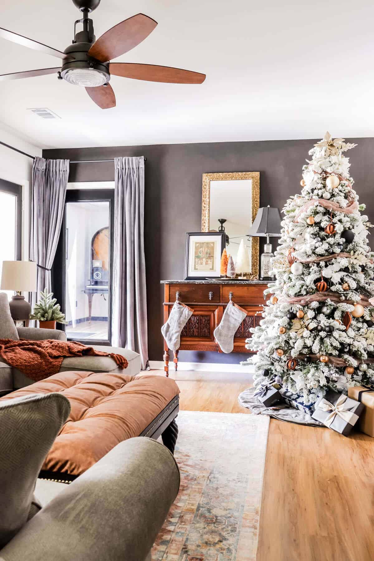 basement family room with moody colors and flocked Christmas tree