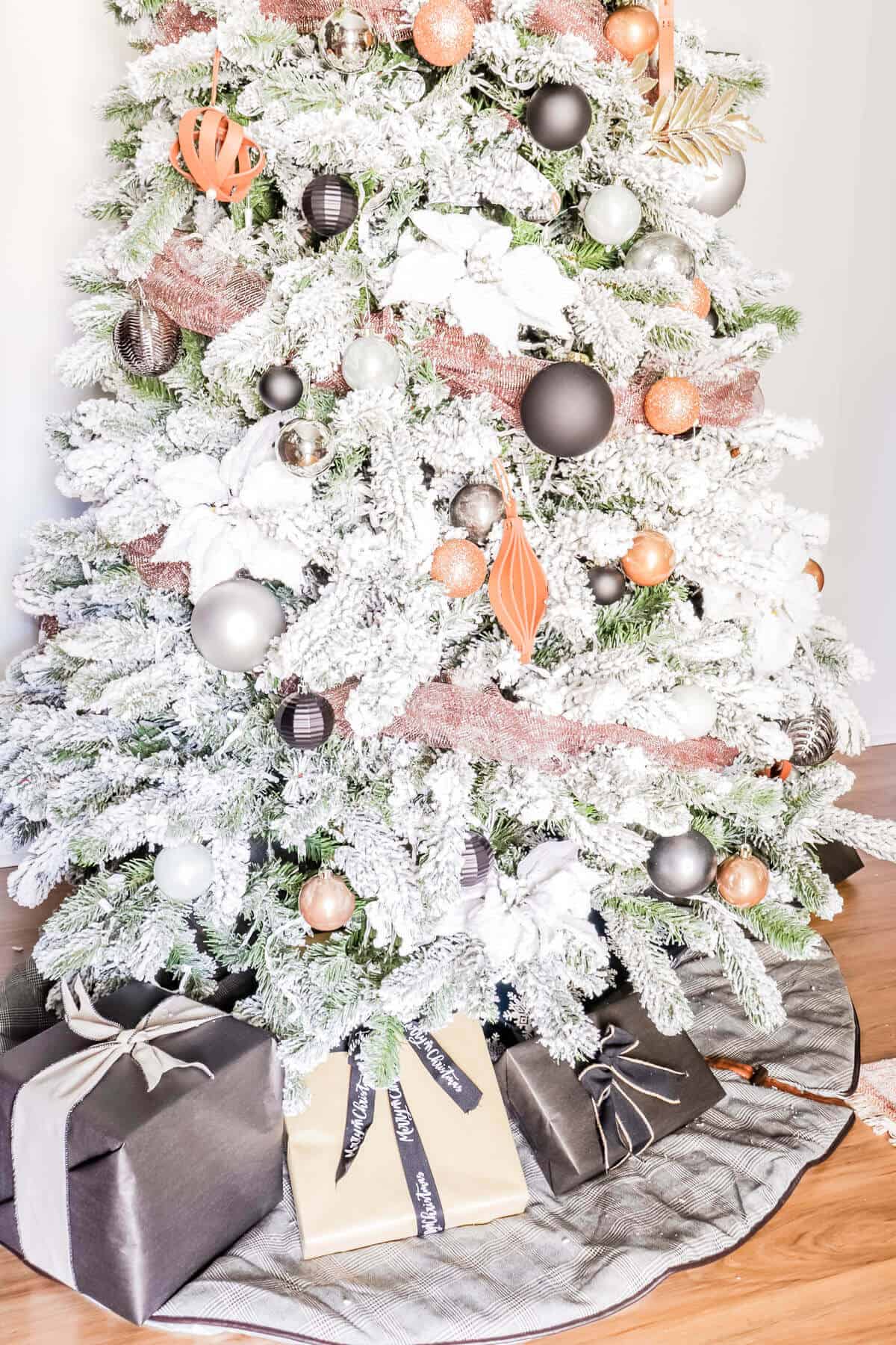 flocked tree with copper, leather, gray and black ornaments