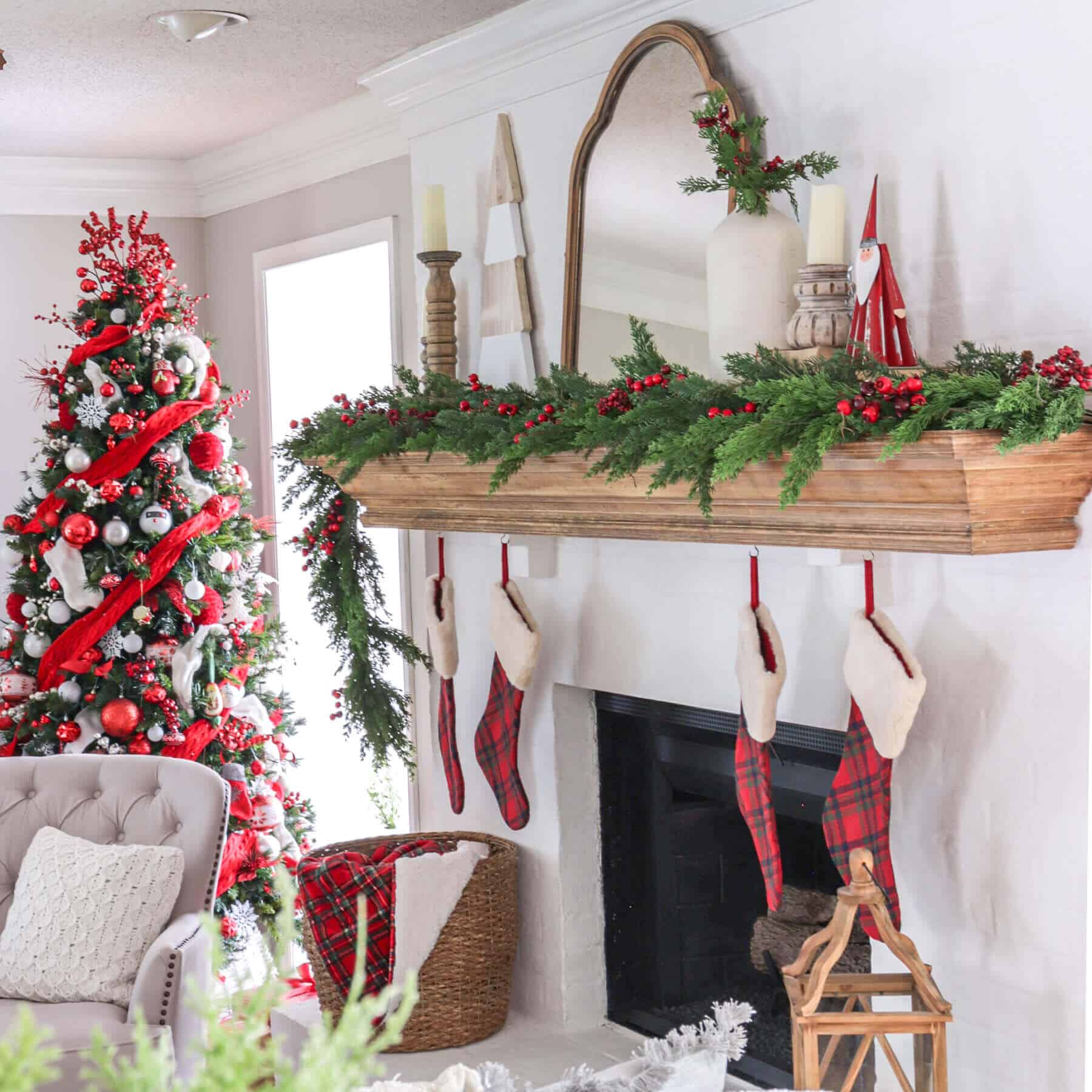 Christmas fireplace mantel decorated with red and white Christmas decorations and tartan plaid stockings