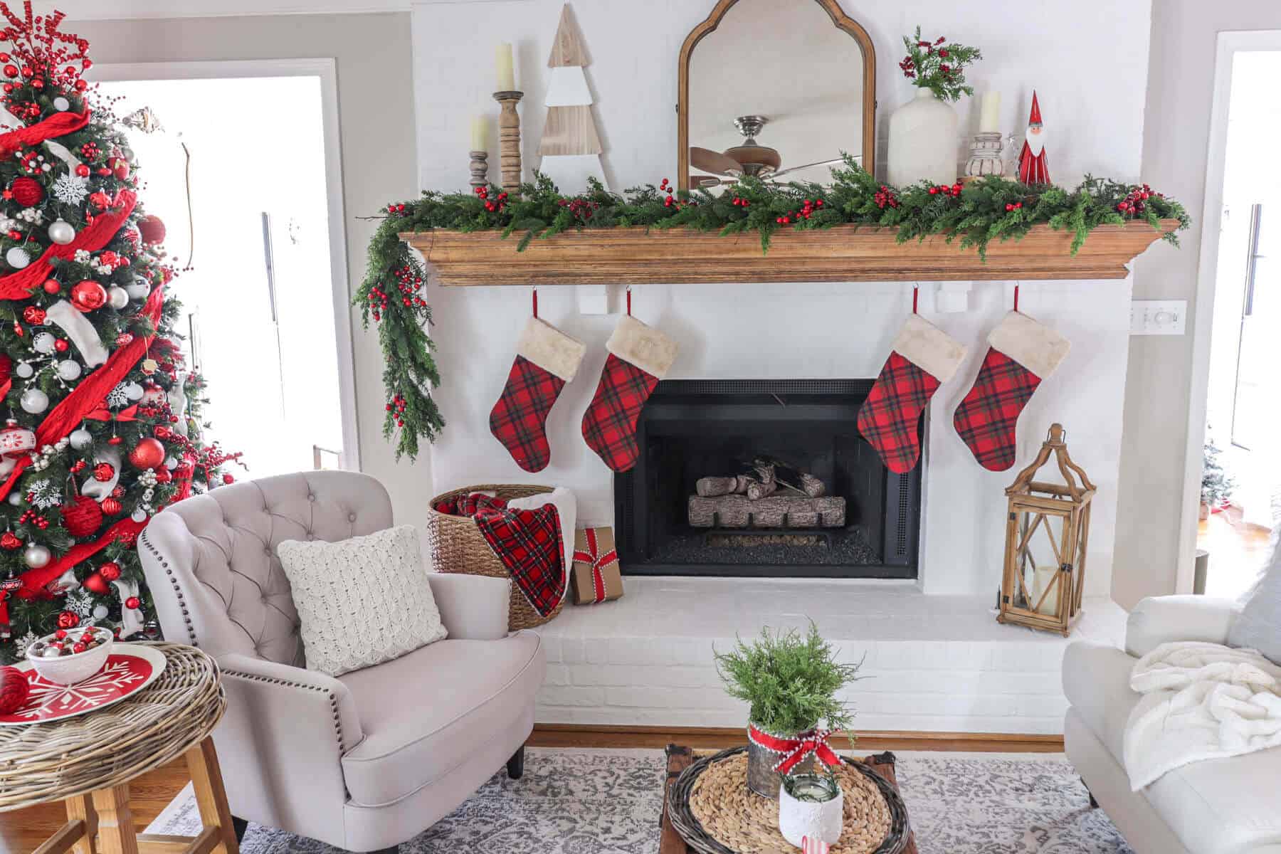 Christmas fireplace mantel decorated with red and white Christmas decorations and tartan plaid stockings