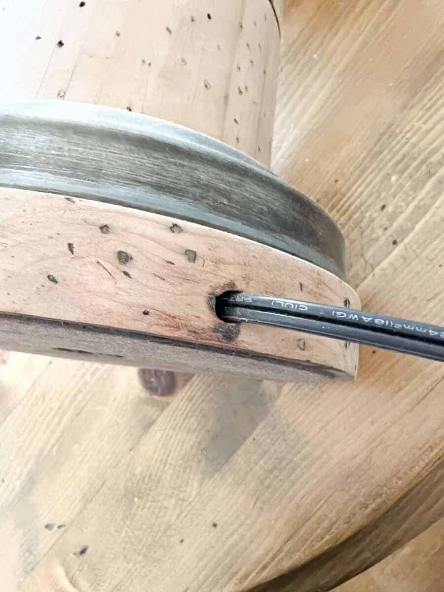 close up of lamp cord coming out of a wooden base