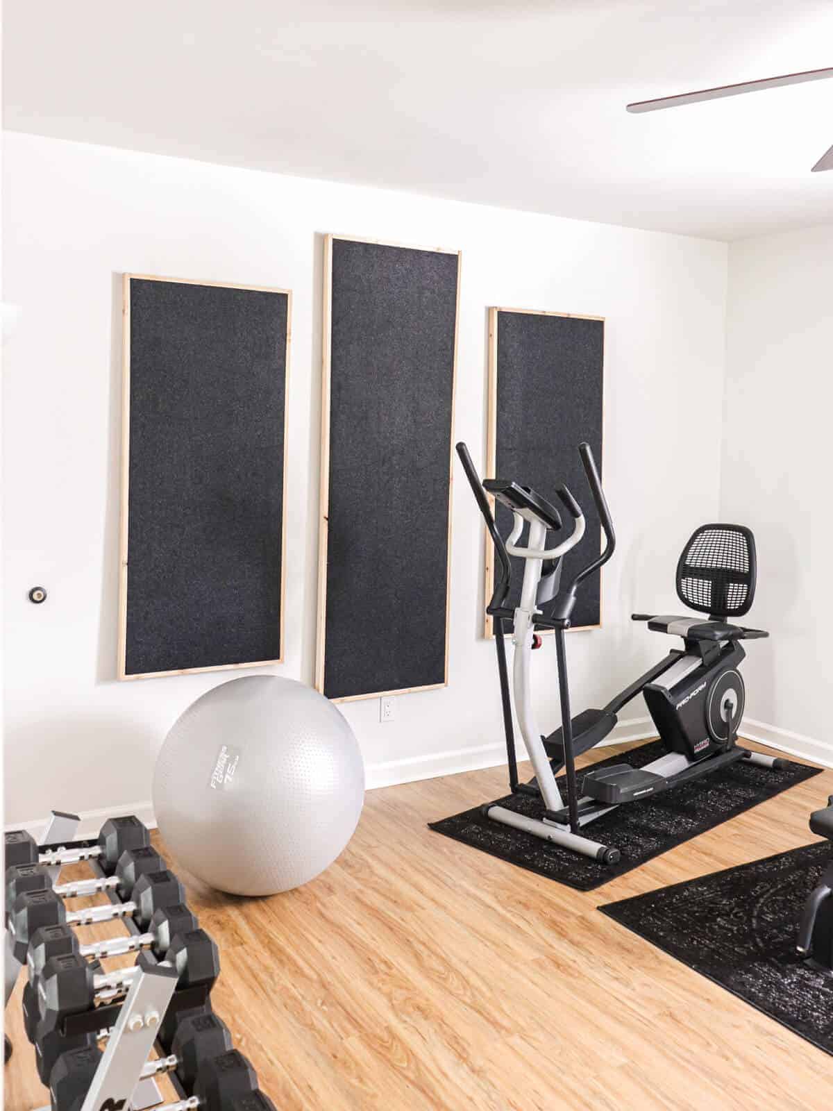 home gym with elliptical machine, yoga ball and wall covered with soundproof panels