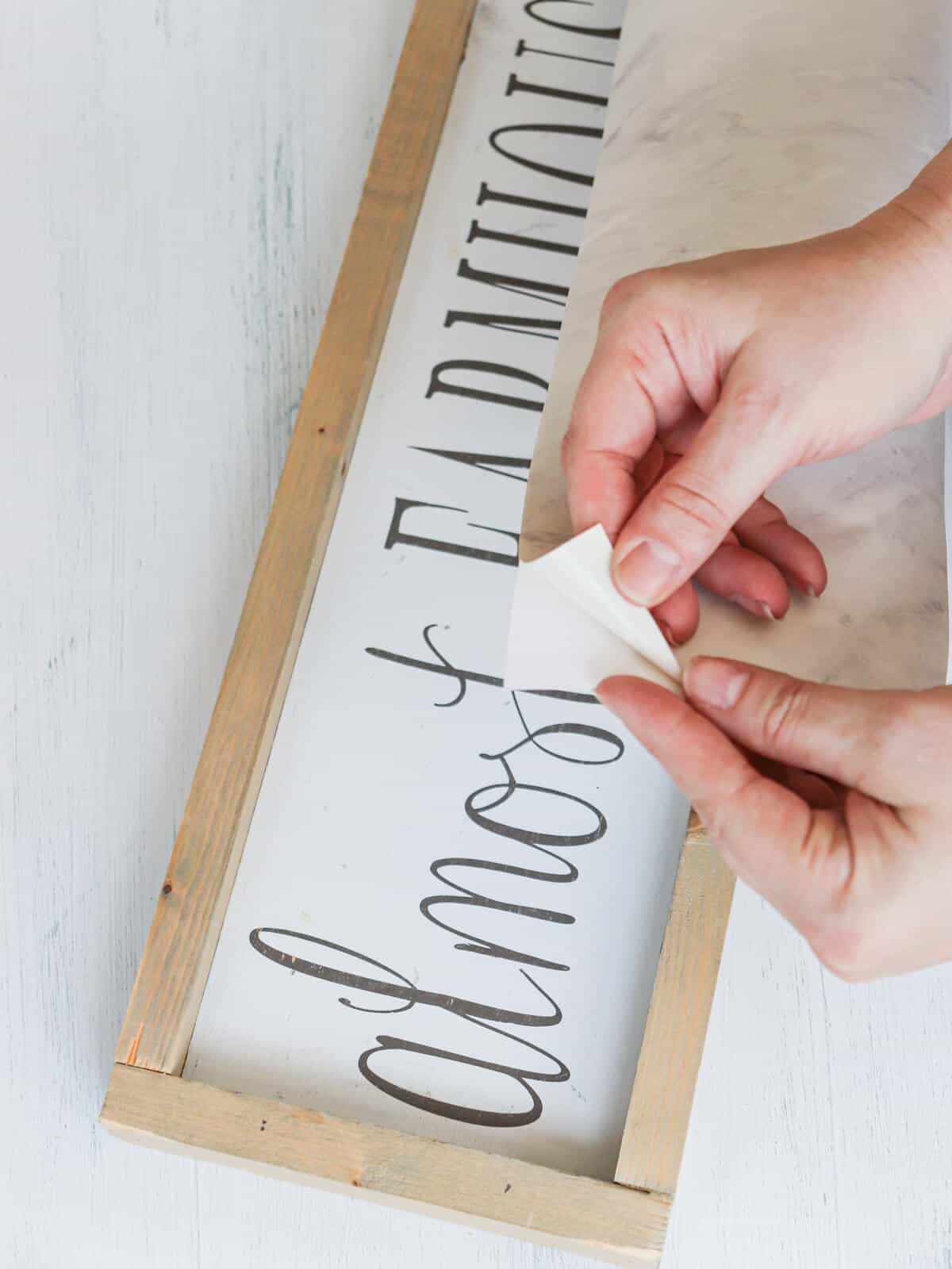 applying marble contact paper to wooden sign