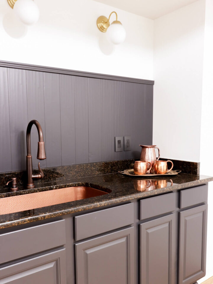 gray cabinetry with a copper sink and faucet