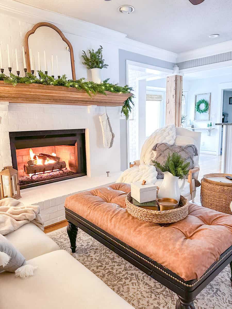 cozy armchairs next to a fireplace decorated for christmas