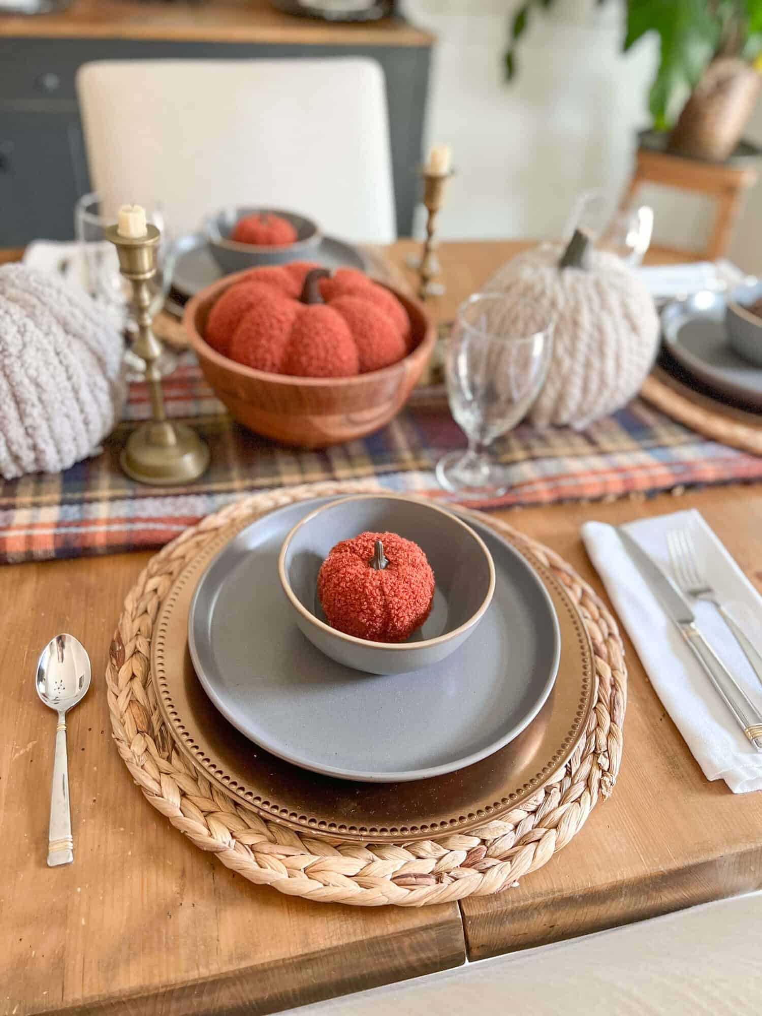 simple thanksgiving tablescape with gray plates and dark orange pumpkins