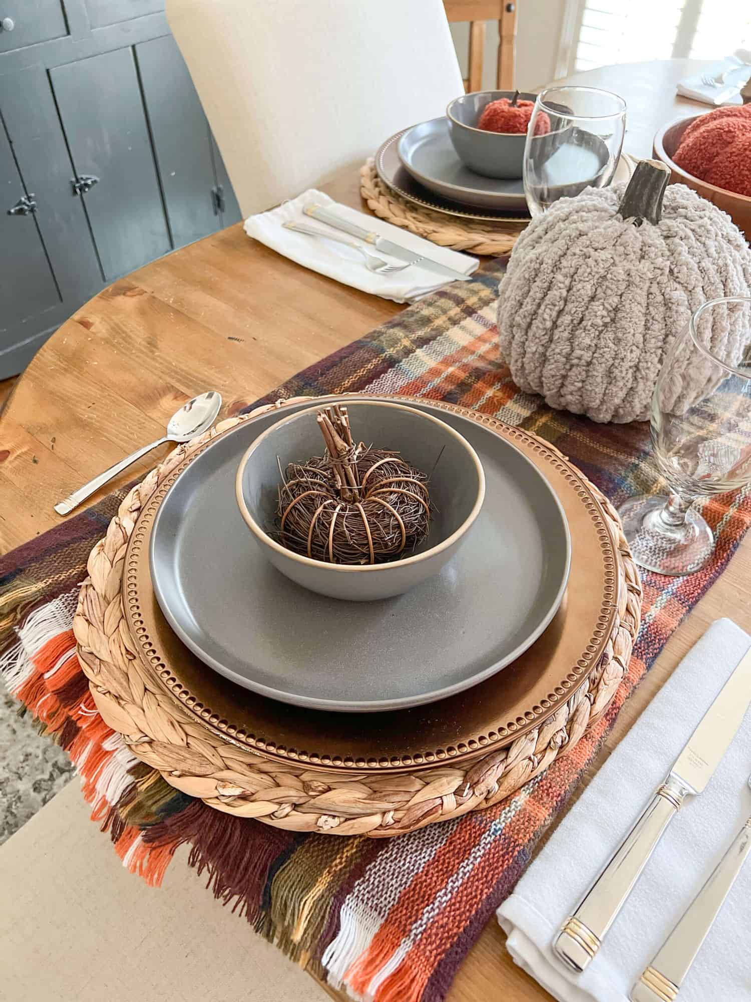 simple thanksgiving tablescape with gray plates and woven pumpkins