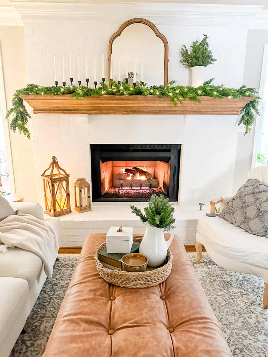 lit slurried gas fireplace with wood mantel decorated for winter