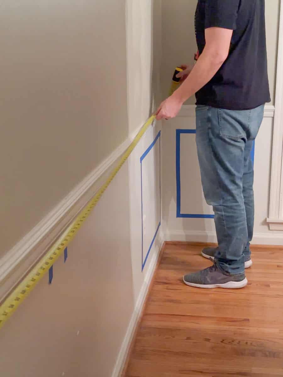 man measuring the length of a wall