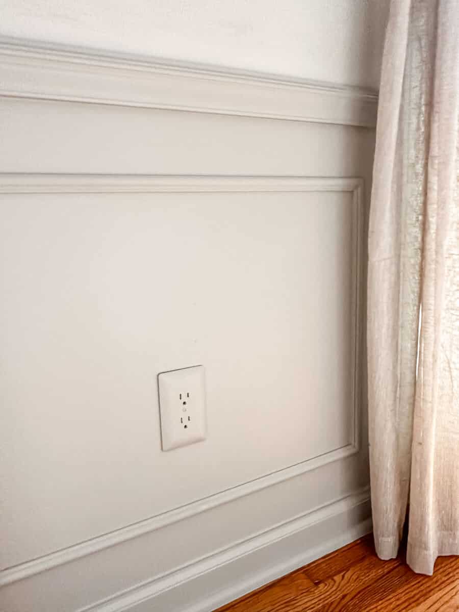 painted wainscoting in dining room with painted outlet cover