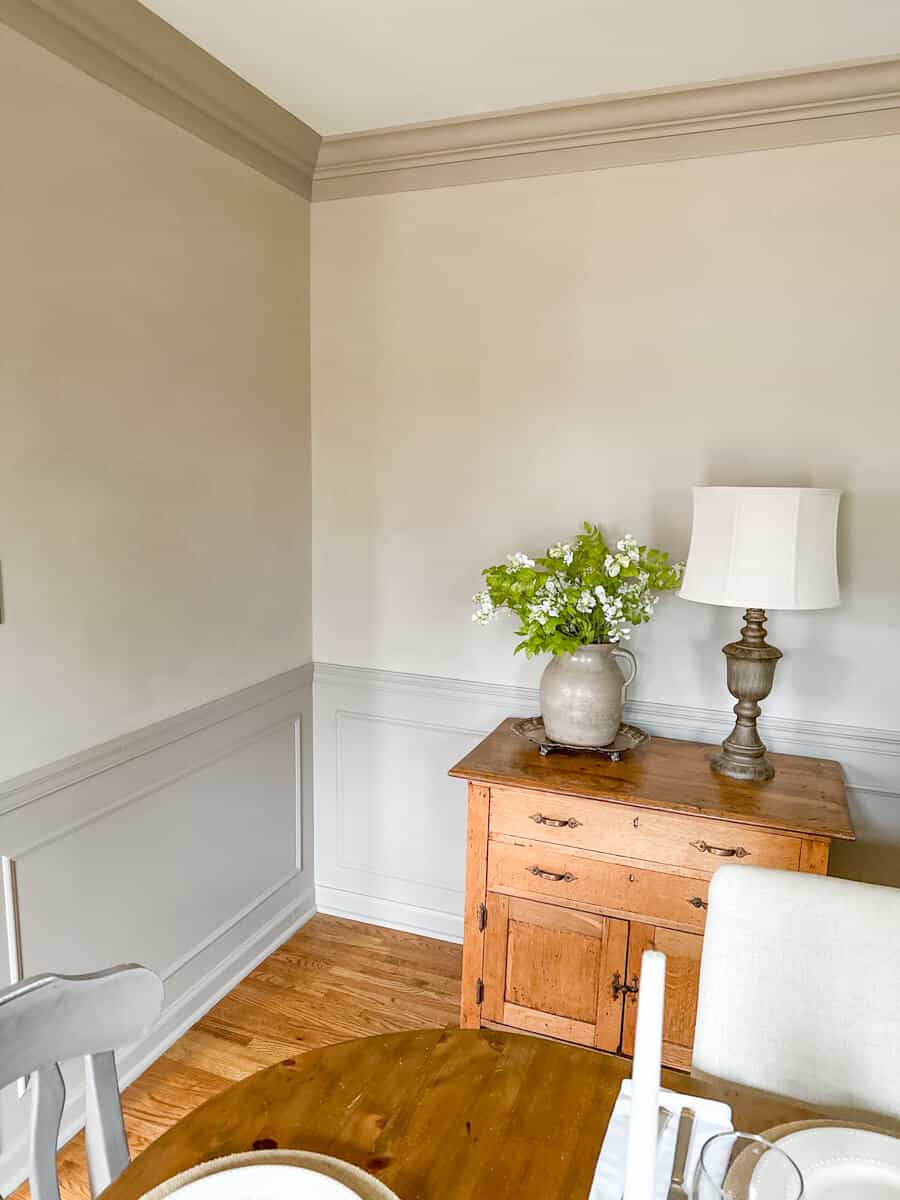 Vintage chest against limewashed walls next to a dining table setting