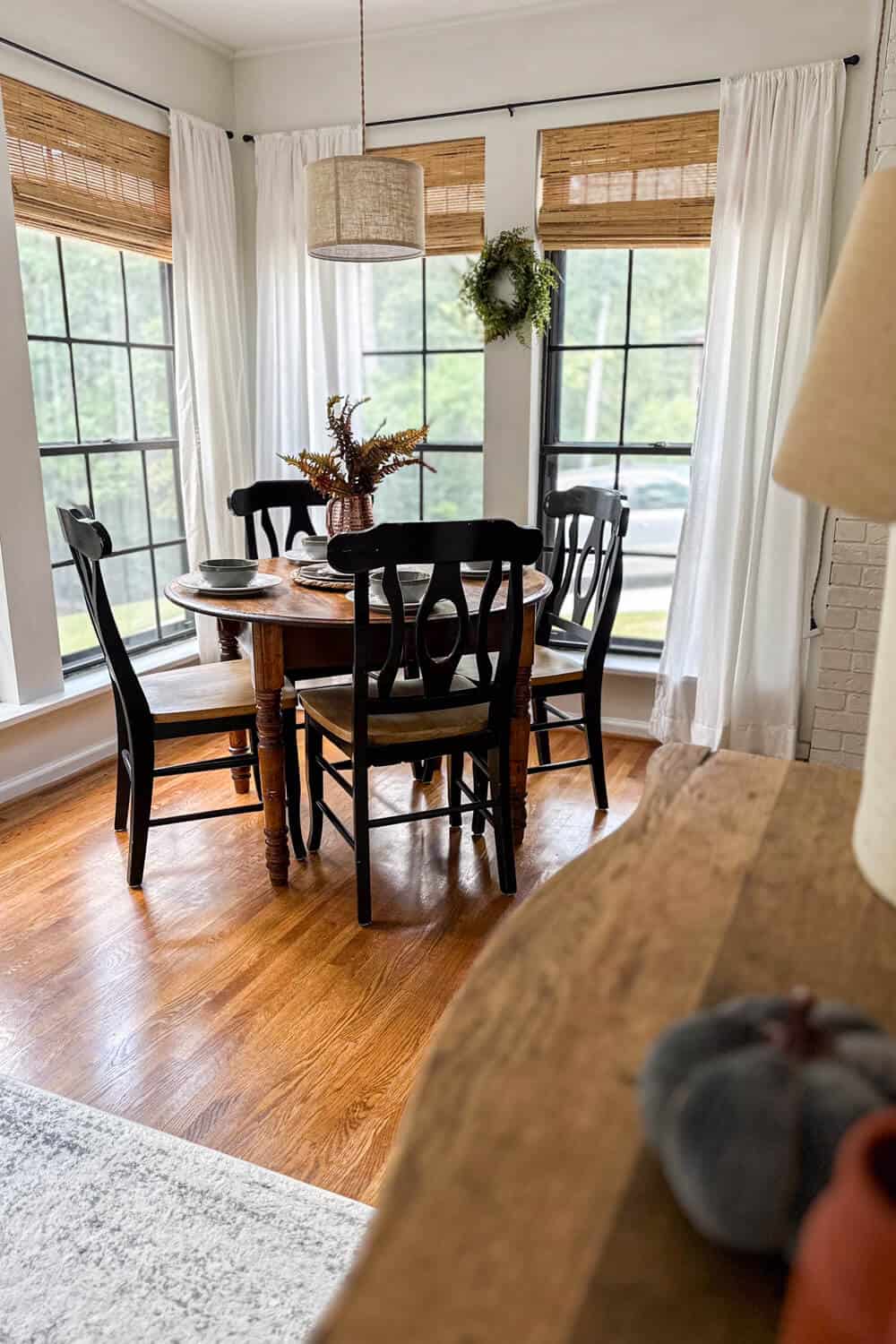 breakfast room with hanging pendant light and black chairs decorated with minimalist fall decor