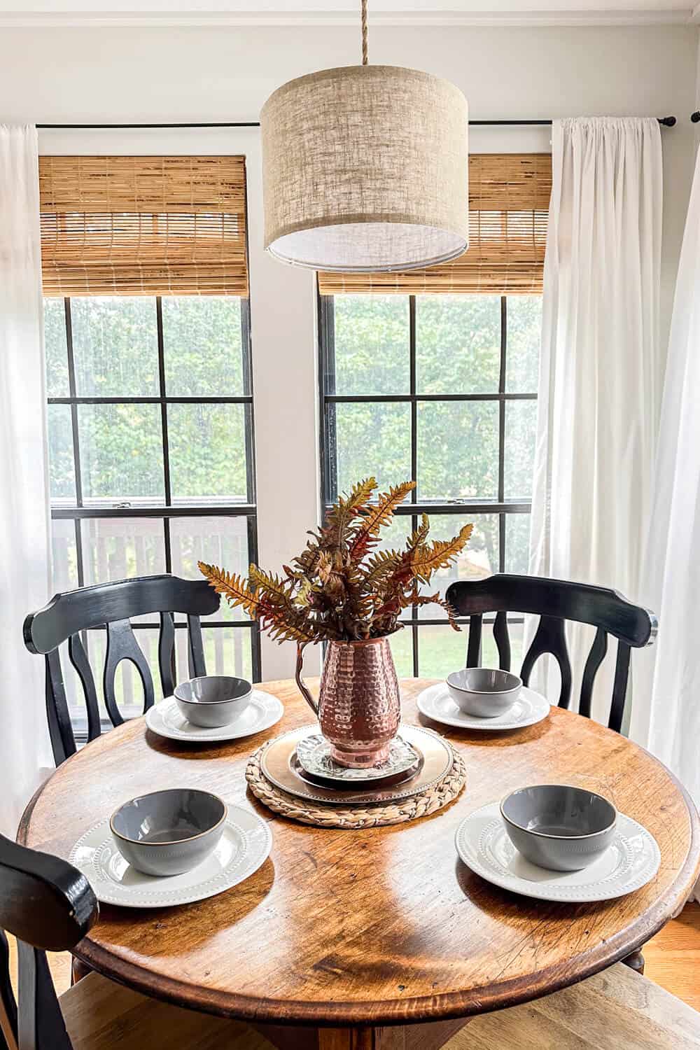 breakfast room table in a sunroom decorated with minimalist fall decor table setting