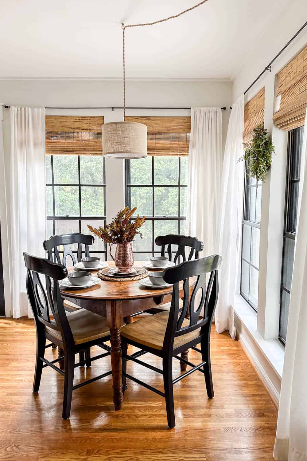 breakfast room with hanging pendant light and black chairs decorated with minimalist fall decor