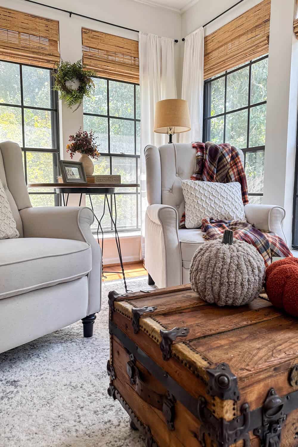 Pair of wingback armchairs in front of black windows decorated with minimal fall decor