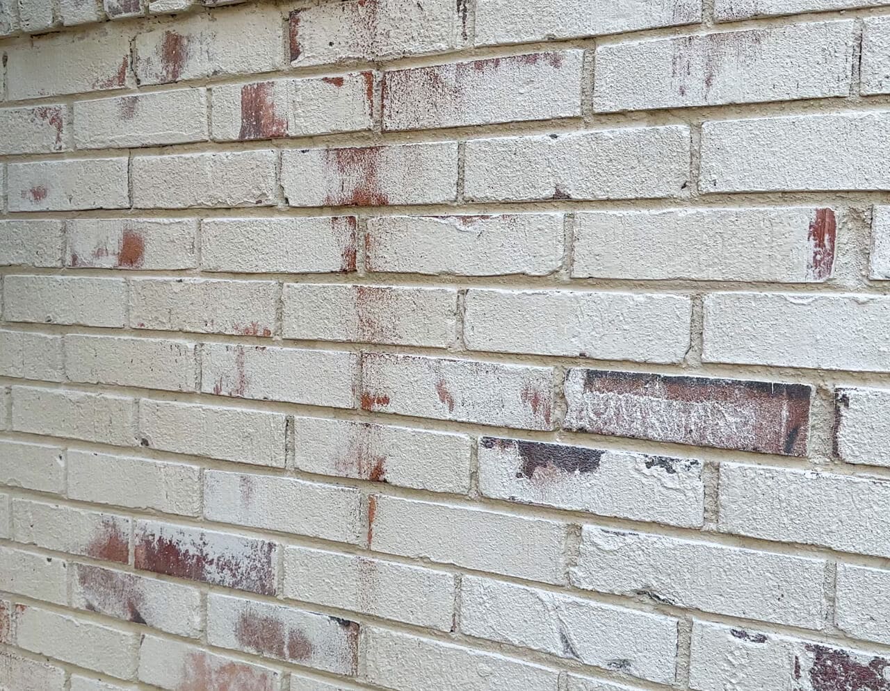 close up of distressed brick painted with Romabio Classico limewash in riposo beige