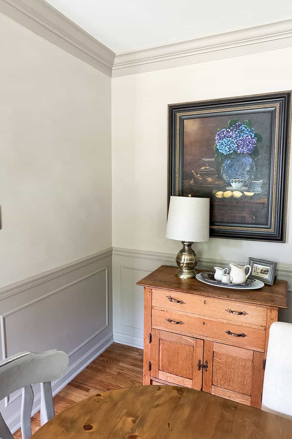 oil painting with hydrangeas hanging on a limewashed wall in a dining room
