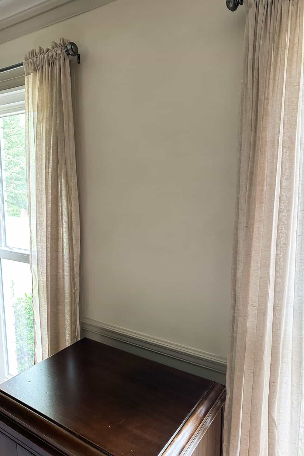 linen curtains hanging on limewashed wall