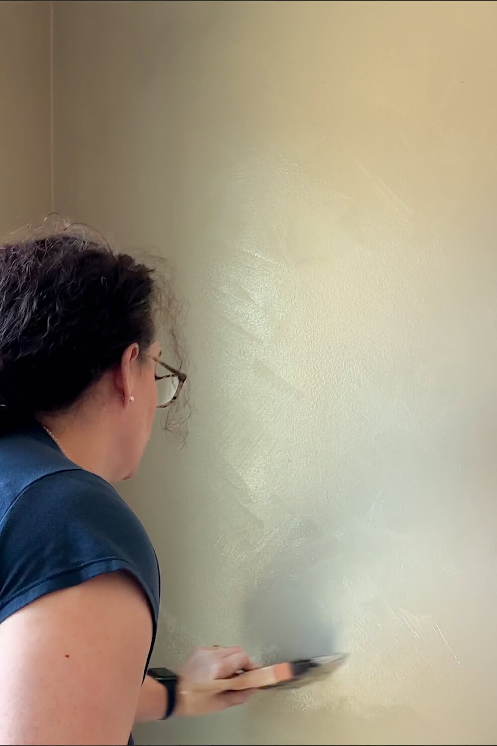 woman painting a wall with limewash paint